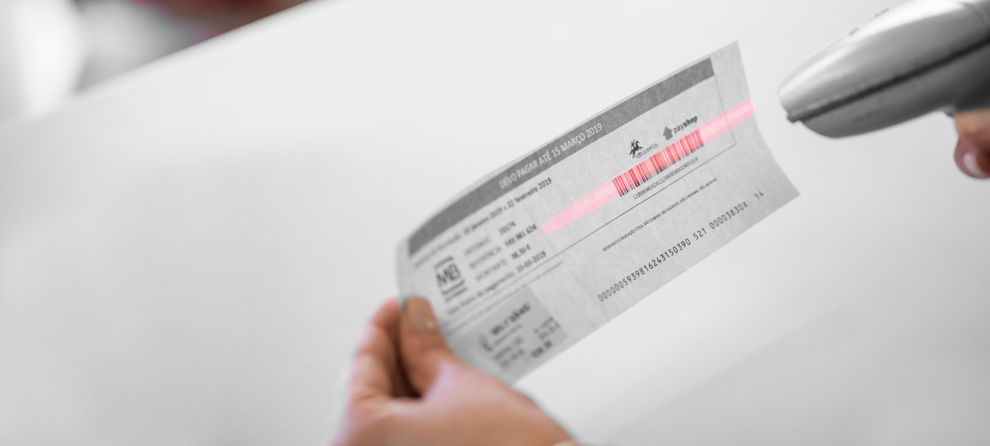 Pessoa a pistolar um código de barras para efetuar o pagamento.