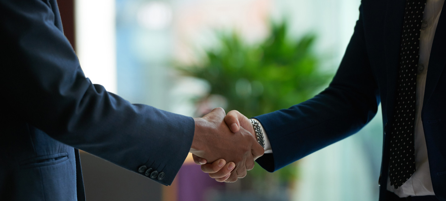 Dois senhores a darem um aperto de mão.