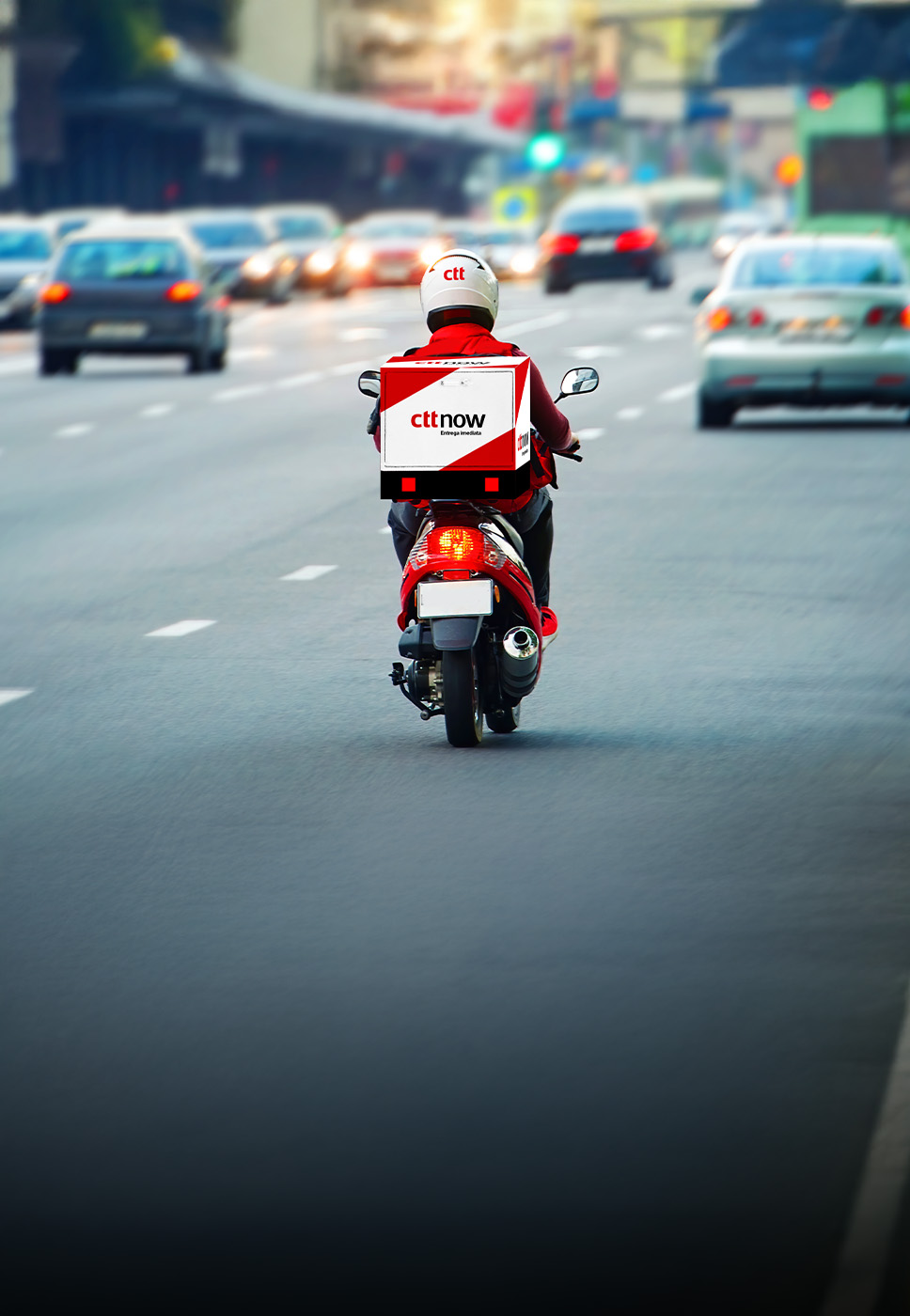 Um estafeta numa mota a entregar uma encomenda enviada através do serviço CTT Now